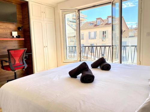 une chambre avec un lit blanc avec une grande fenêtre dans l'établissement Stylish Cannes Gem, Terrace, Parking, 100m to Croisette, à Cannes