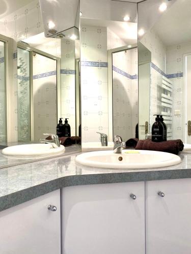 une salle de bain avec deux lavabos et deux miroirs dans l'établissement Stylish Cannes Gem, Terrace, Parking, 100m to Croisette, à Cannes