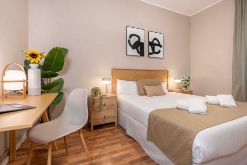 a bedroom with two beds and a desk with a computer at Sagrada familia Secret Apartment in Barcelona