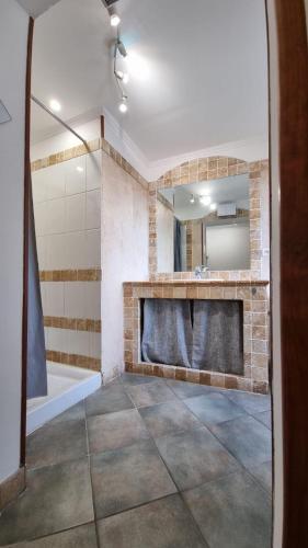 une salle de bain avec une baignoire, un lavabo et un miroir dans l'établissement Appartement Corte centre ville, à Corte