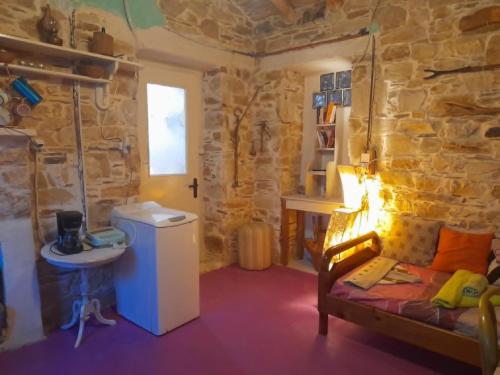 a room with a couch and a sink in a stone wall at Stoneworld in Évdhilos