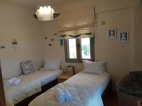 a room with two beds and a chair and a window at Villa Polyxeni 5 Bedrooms and Private Pool in Politiká