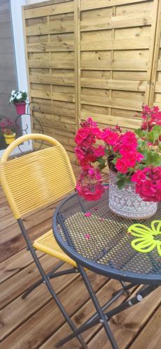 a table and chairs with flowers on a patio at chambre dans maison coquette et accueillante in Dunkerque