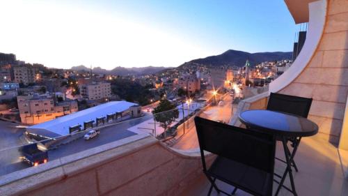 a bar on a balcony with a view of a city at P Quattro Relax Hotel in Wadi Musa
