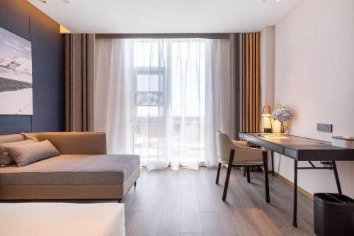 a bedroom with a bed and a desk and a table at Atour Hotel Beijing Capital Airport New International Exhibition Center in Beijing
