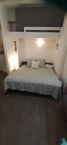 une chambre avec un lit avec deux oreillers dessus dans l'établissement Superbe Studio avec place de parking accès direct à la plage de Renecros Tout à pied linge de lit, serviettes de bain et ménage de fin de séjour inclus, à Bandol