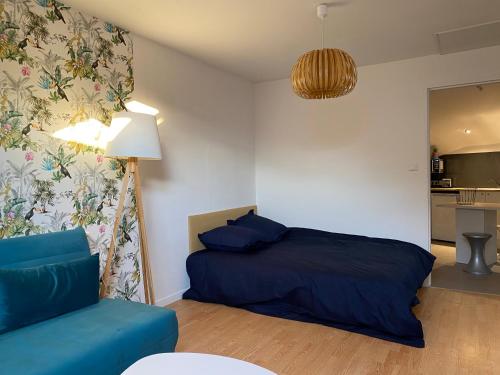 - une chambre avec un lit bleu et un canapé dans l'établissement Chambre dans colocation Cholet Centre, à Cholet