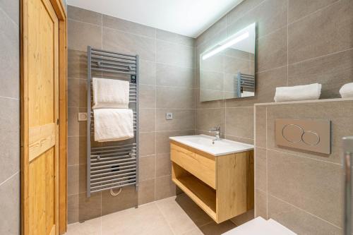 une salle de bain avec un lavabo et un miroir dans l'établissement SmartStay - Super Morzine, à Morzine
