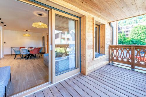 un porche grillagé avec vue sur une table à manger dans l'établissement SmartStay - Super Morzine, à Morzine