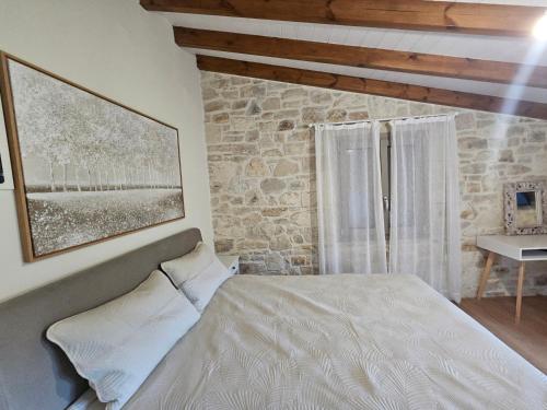 a bedroom with a bed and a stone wall at Gem apartment Analipsi in Hersonissos