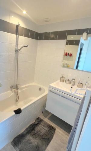 une salle de bain avec une baignoire et un lavabo dans l'établissement Vue citadelle avec wifi et climatisation, à Calvi