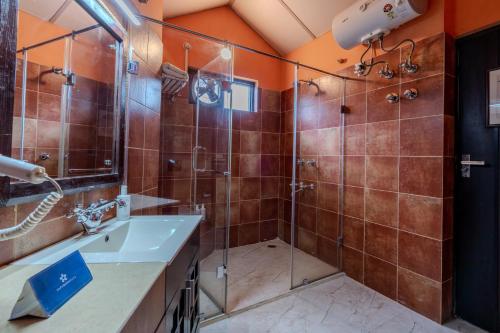 a bathroom with a shower and a sink at SaffronStays The Divine Hima in Dharamshala