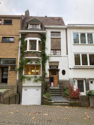 una casa con un garage bianco davanti di Calm, green & birdsong near the city center a Bruxelles
