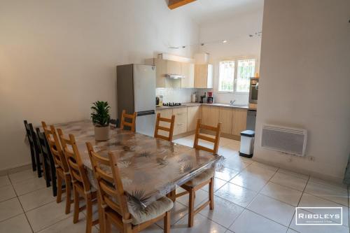 - une cuisine avec une table à manger et des chaises dans l'établissement Villa T4 à 450m de la plage avec climatisation, à Vias