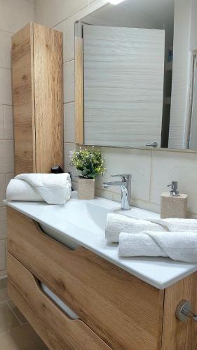 a bathroom sink with two towels and a mirror at Il Pumo Salentino in Lecce