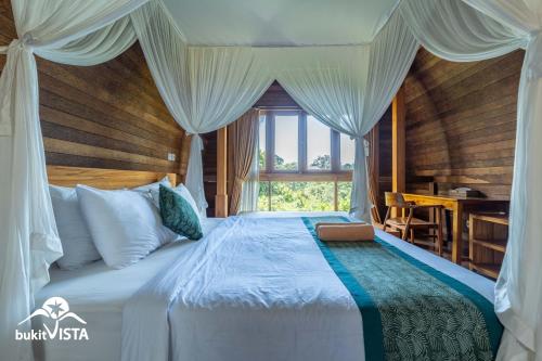a bedroom with a bed with a window and a desk at Pondok Nini Bungalow by Bukit Vista in Ubud