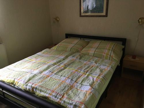 a bed with a plaid comforter in a bedroom at Seemann,Familie Ferienwohnung Seemann in Güstrow