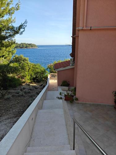 a walkway next to a building with a view of the water at Apartments Maskovic Karbuni in Prizba