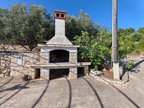 a stone fireplace with a tower on top of it at Apartments Maskovic Karbuni in Prizba