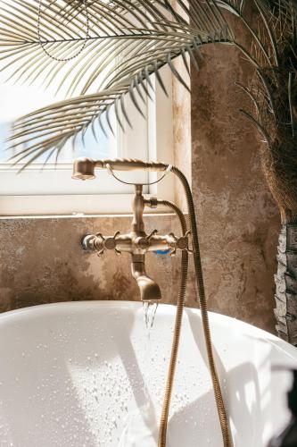 a bath tub with a water faucet at Mustang 11-11 Boutique Hotel Self Check In in Ho Chi Minh City