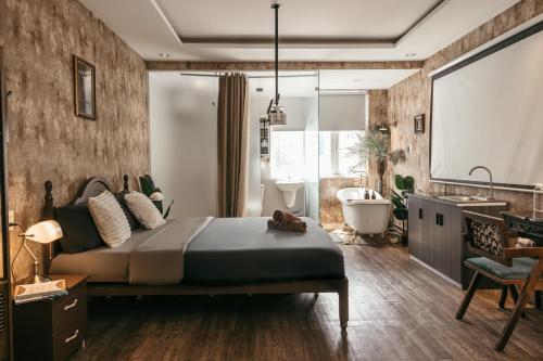 a bedroom with a bed and a tub and a bathroom at Mustang 11-11 Boutique Hotel Self Check In in Ho Chi Minh City