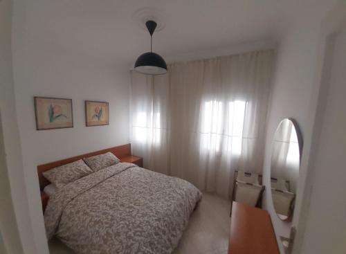 a bedroom with a bed and a mirror at Miramar Beach Martil in Martil