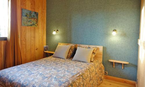 ein Schlafzimmer mit einem Bett mit zwei Kissen darauf in der Unterkunft Villa Naïade, Lège-Cap-Ferret, Arcachon Bay in Lège-Cap-Ferret