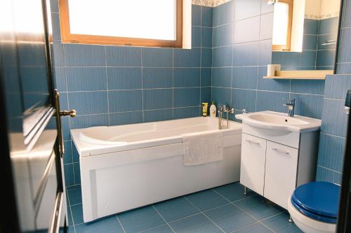 a blue bathroom with a tub and a sink at Pensiunea Tania-Nora in Alexandru cel Bun 