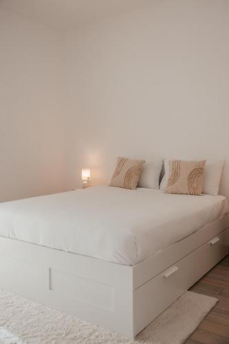 a white bed with white sheets and pillows at Desert Home Abu Dhabi in Abu Dhabi