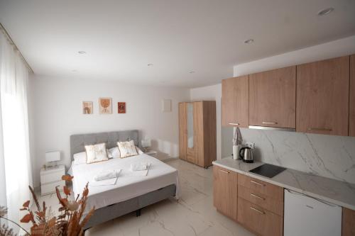 Un dormitorio blanco con una cama y una cocina. en Apartment House LUX - Vodice, en Vodice