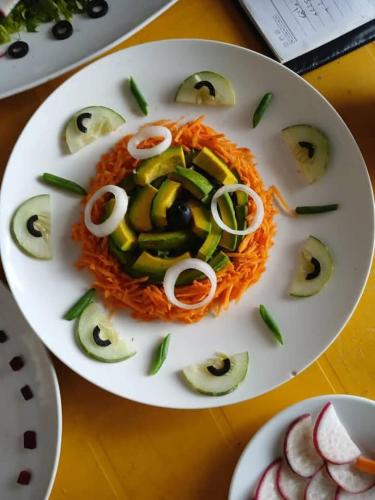 a plate of food with cucumbers and onions on it at Hôtel RIO Ouidah in Kika
