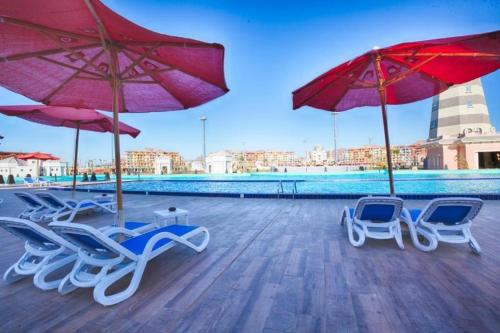 a group of chairs and umbrellas next to a pool at Elegant Apartments & Aquapark - B&B- FREE WI-FI-Sharm El Sheikh in Sharm El Sheikh