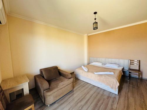 a bedroom with a bed and a chair at Guest House Sanapiro in Tʼelavi