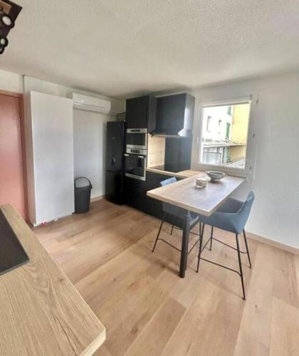 une cuisine avec une table et des chaises dans une pièce dans l'établissement Apartment 2p with Wifi in the heart of Fréjus, à Fréjus
