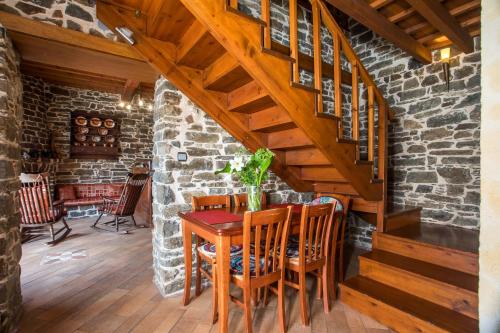 a dining room with a wooden table and stairs at Echo Traditional House - Ηχώ Παραδοσιακό Σπίτι in Émbonas