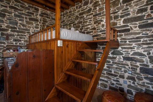 a wooden staircase in a room with a brick wall at Echo Traditional House - Ηχώ Παραδοσιακό Σπίτι in Émbonas