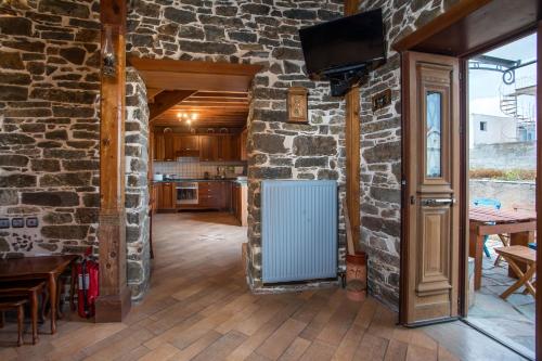 a kitchen with a stone wall and a blue radiator at Echo Traditional House - Ηχώ Παραδοσιακό Σπίτι in Émbonas