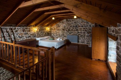 a room with a bed and a stone wall at Echo Traditional House - Ηχώ Παραδοσιακό Σπίτι in Émbonas