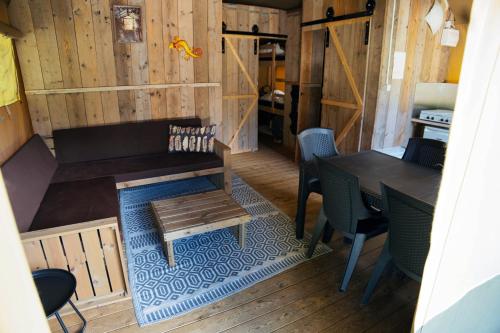 a room with a bench and a table and chairs at Camping 2000 - Sahara tent XXL in Osečná