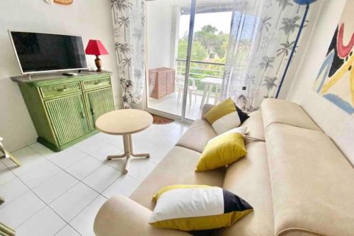 un salon avec un canapé et une télévision dans l'établissement Apartment with pool near the sea, à Saint-Raphaël