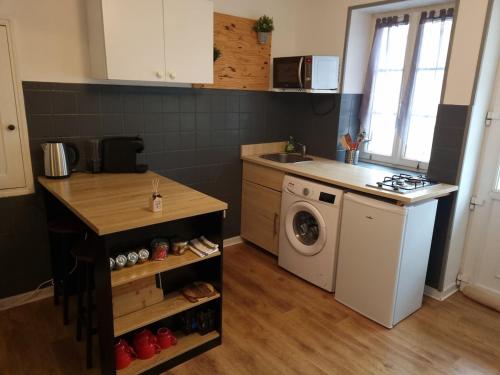 une cuisine avec un évier et une machine à laver dans l'établissement Quincey Village House, à Quincey