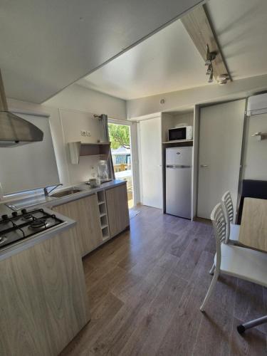 Il comprend une cuisine équipée d'une cuisinière. four supérieur à côté d'une table dans l'établissement Le cessonnais, à Cessenon