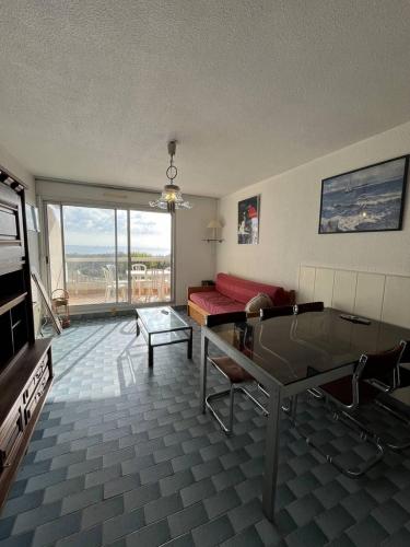 un salon avec un canapé rouge et une table en verre dans l'établissement Au couchant logement pour 4 personnes N70, à La Grande Motte