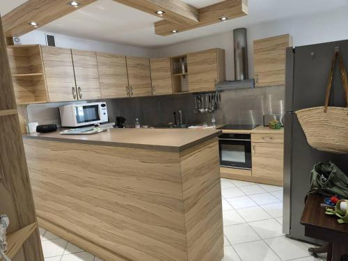 une cuisine avec des armoires en bois et un comptoir dans l'établissement Au centre ville, appartement t4 climatisé avec parking N72, à La Grande Motte