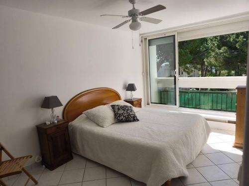 une chambre avec un lit et une grande fenêtre dans l'établissement Au centre ville, appartement t4 climatisé avec parking N72, à La Grande Motte