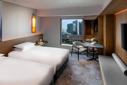 a hotel room with two beds and a desk at Hyatt Regency Tokyo in Tokyo