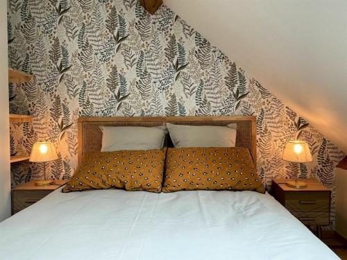 a bed with two pillows in a bedroom with two lamps at Loustalot in Aydius