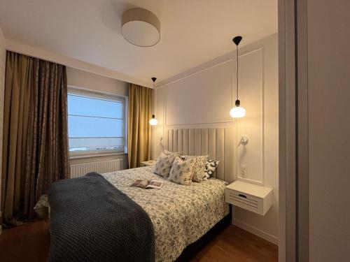 a hotel room with a bed and a window at Apartament Olimpia in Lębork