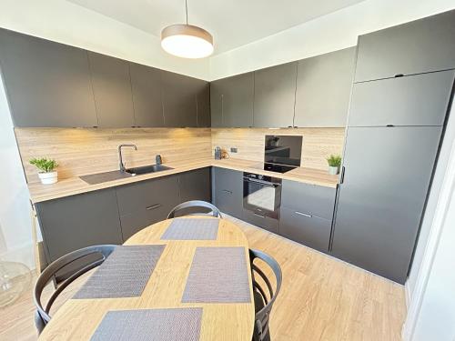 une cuisine avec une table, des chaises et un réfrigérateur dans l'établissement Nuit des Sacres, à Reims