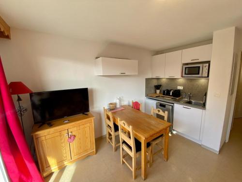 une petite cuisine avec une table en bois et une kitchenette avec une table et des chaises dans l'établissement T2 view, skiing, summer pool Balcons du Soleil, à Allos